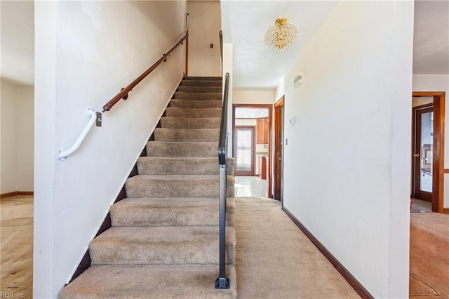 staircase featuring carpet flooring