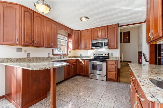 kitchen featuring light stone countertops, appliances with stainless steel finishes, sink, and kitchen peninsula