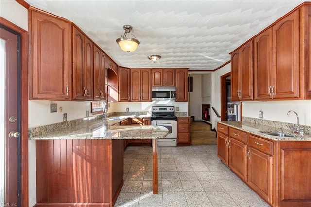 kitchen with light stone countertops, appliances with stainless steel finishes, and sink