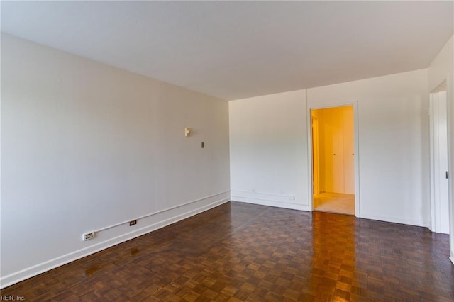 unfurnished room featuring dark parquet flooring