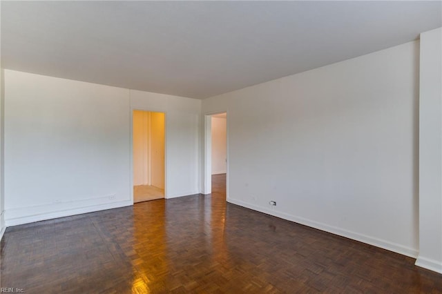 unfurnished room with dark parquet flooring