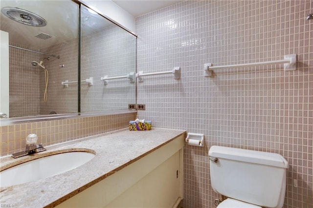 bathroom featuring tile walls, backsplash, tiled shower, vanity, and toilet