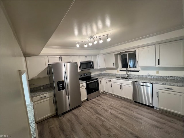 kitchen featuring appliances with stainless steel finishes, dark hardwood / wood-style floors, sink, white cabinets, and ornamental molding