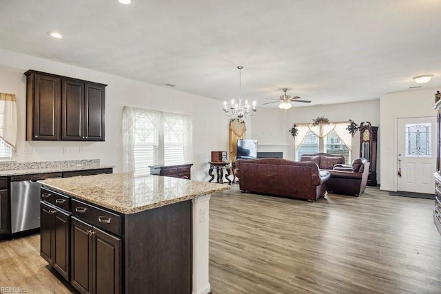 kitchen featuring stainless steel dishwasher, dark brown cabinetry, a center island, and light wood-type flooring