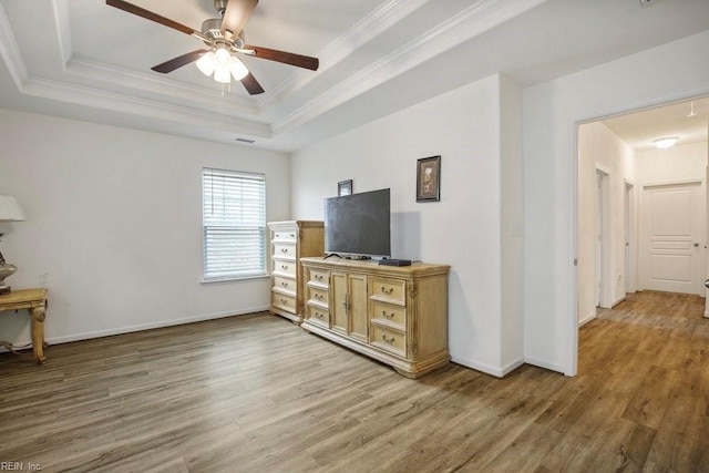 living room featuring crown molding, a tray ceiling, wood-type flooring, and ceiling fan