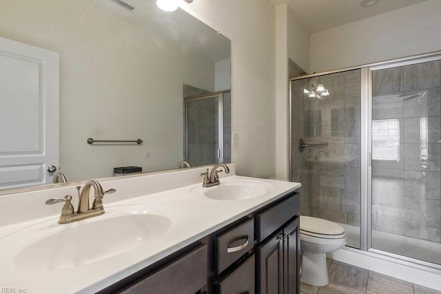 bathroom featuring vanity, toilet, and a shower with shower door