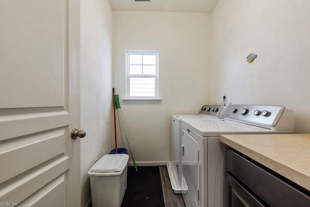 washroom with hardwood / wood-style flooring and washer and dryer