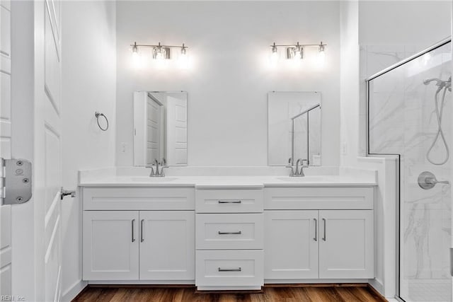 bathroom featuring hardwood / wood-style flooring, vanity, and walk in shower