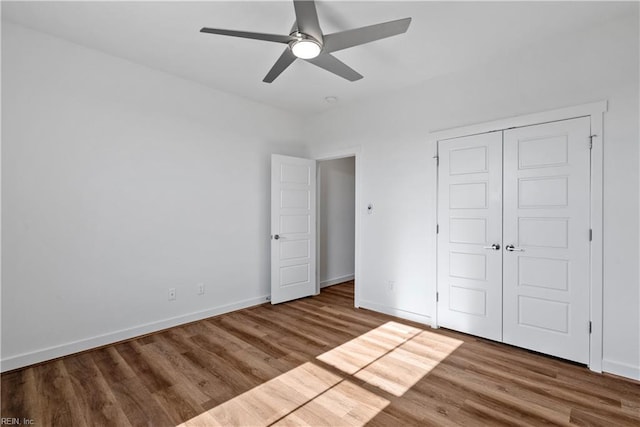 unfurnished bedroom with ceiling fan, wood-type flooring, and a closet