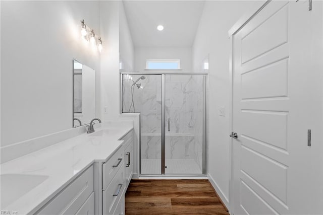 bathroom with vanity, wood-type flooring, and a shower with door