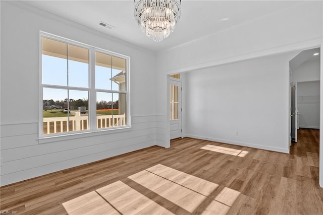 unfurnished room featuring hardwood / wood-style floors and a chandelier