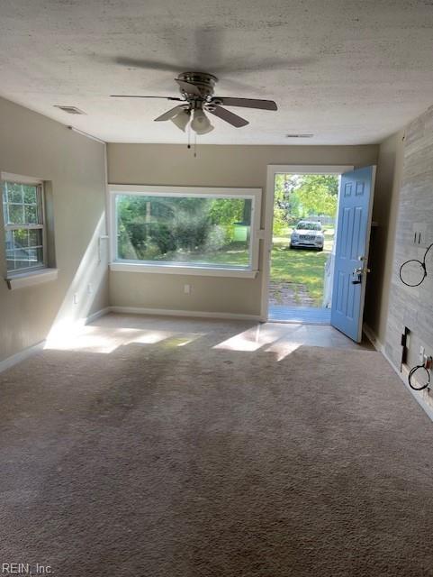 unfurnished living room with ceiling fan, carpet floors, and a textured ceiling