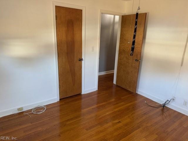 unfurnished bedroom with dark hardwood / wood-style flooring