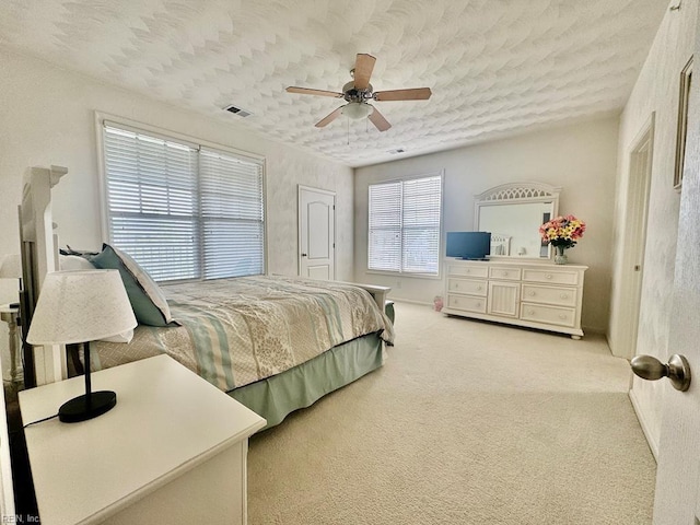 carpeted bedroom featuring a textured ceiling and ceiling fan