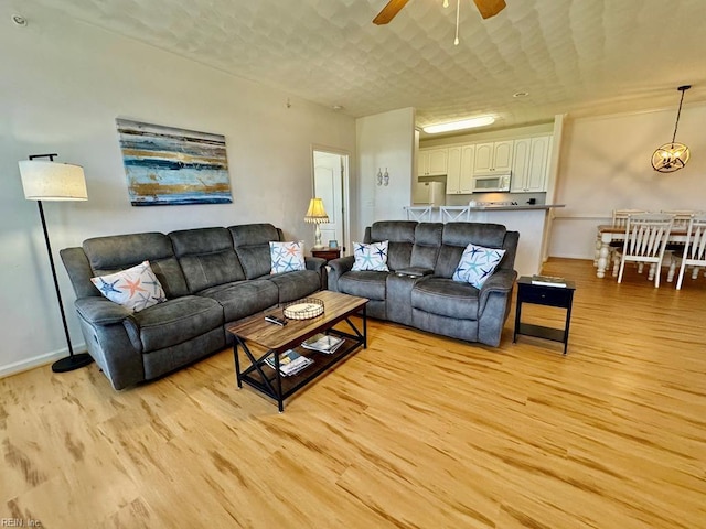 living room featuring ceiling fan and light wood-type flooring