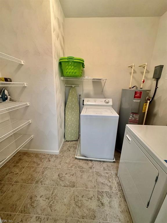 laundry room featuring water heater and washer and clothes dryer