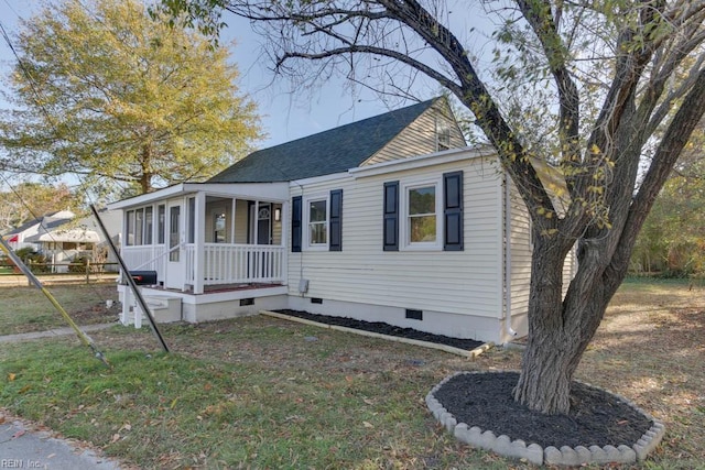 view of front facade with a sunroom and a front yard