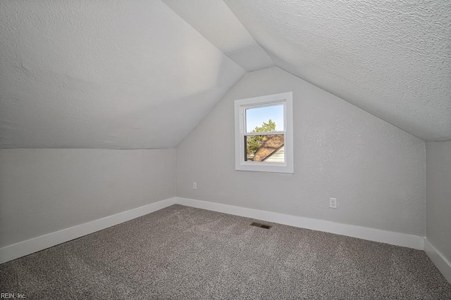 bonus room with lofted ceiling, a textured ceiling, and carpet flooring