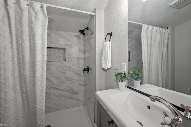 bathroom with vanity, curtained shower, and a textured ceiling