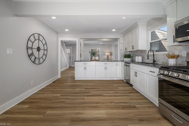 kitchen with dark hardwood / wood-style flooring, sink, white cabinets, and appliances with stainless steel finishes