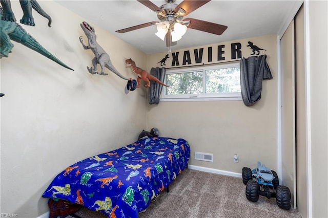 carpeted bedroom with ceiling fan and a closet