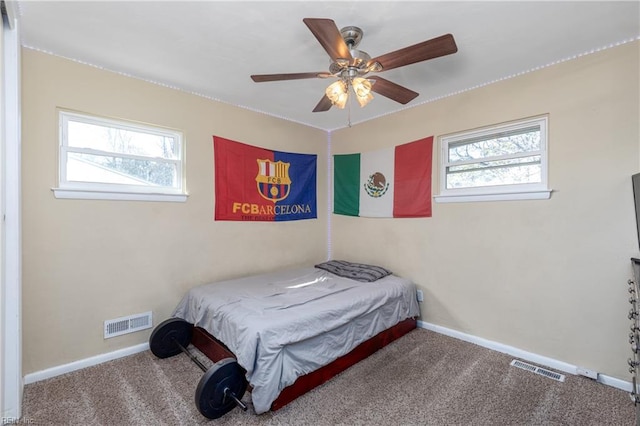 carpeted bedroom with ceiling fan and multiple windows