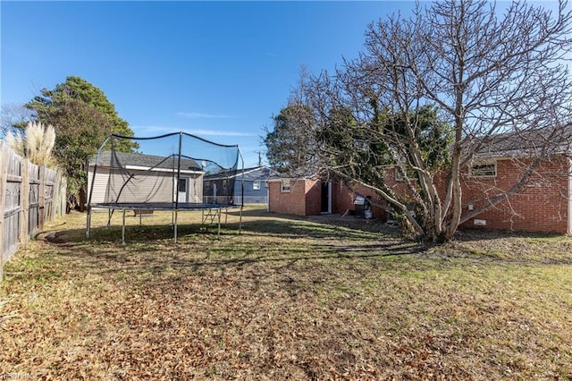 view of yard with a trampoline and a storage shed