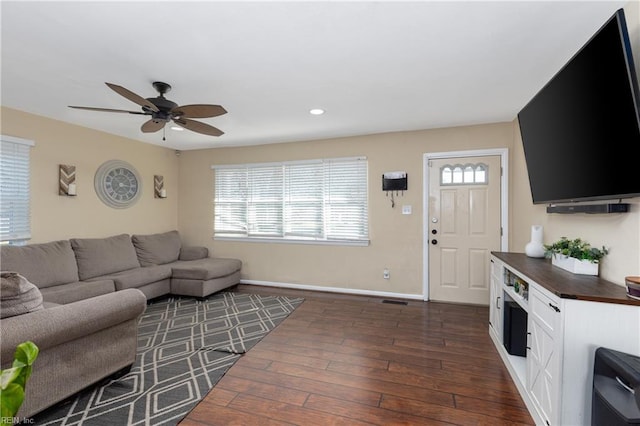 living room featuring ceiling fan and dark hardwood / wood-style flooring