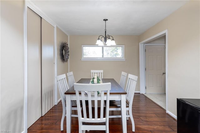 dining area featuring an inviting chandelier and dark hardwood / wood-style floors