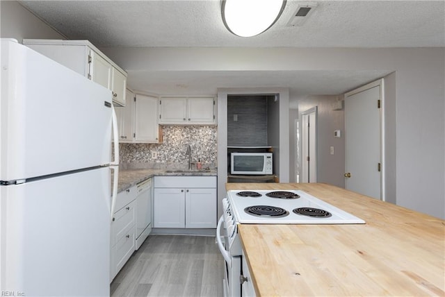 kitchen featuring tasteful backsplash, sink, white cabinets, and white appliances