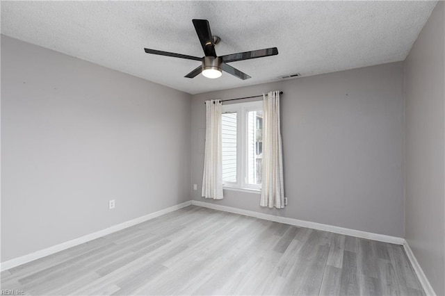 spare room with a textured ceiling, ceiling fan, and light hardwood / wood-style flooring