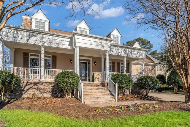 view of front of home featuring covered porch and a chimney