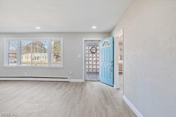 foyer entrance featuring light wood-type flooring and baseboard heating