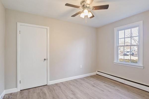 empty room with light hardwood / wood-style flooring, a baseboard radiator, and ceiling fan