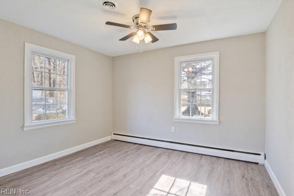 empty room with a baseboard heating unit, ceiling fan, and light wood-type flooring