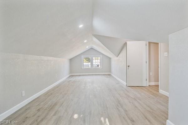 additional living space with lofted ceiling and light hardwood / wood-style flooring