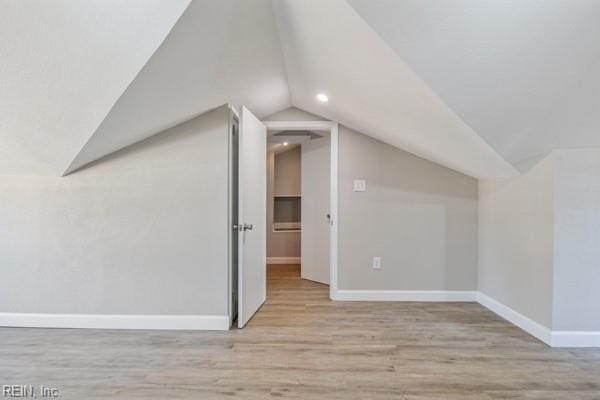 additional living space with lofted ceiling and light hardwood / wood-style floors