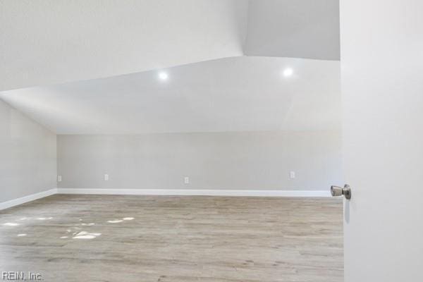 spare room with lofted ceiling and light hardwood / wood-style floors