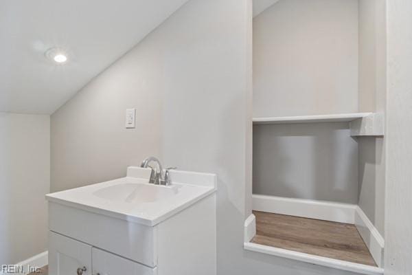 bathroom with lofted ceiling and vanity