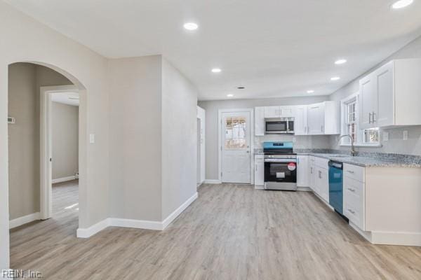 kitchen featuring sink, light hardwood / wood-style flooring, stainless steel appliances, light stone counters, and white cabinets