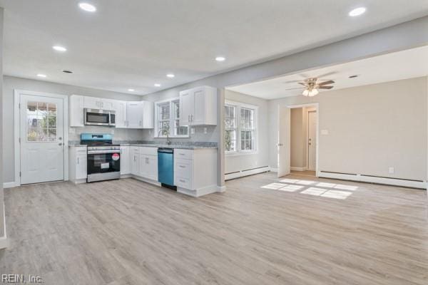 kitchen featuring a baseboard radiator, appliances with stainless steel finishes, light hardwood / wood-style flooring, and white cabinets