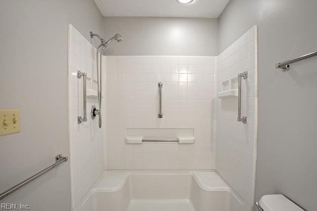 bathroom featuring toilet and tiled shower