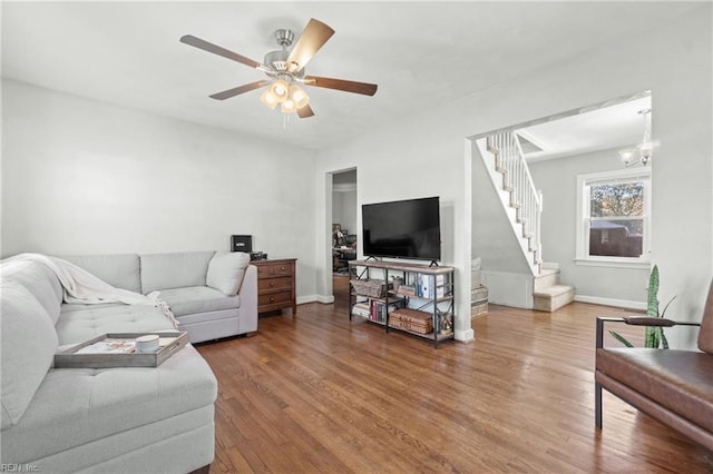 living room with hardwood / wood-style floors and ceiling fan with notable chandelier