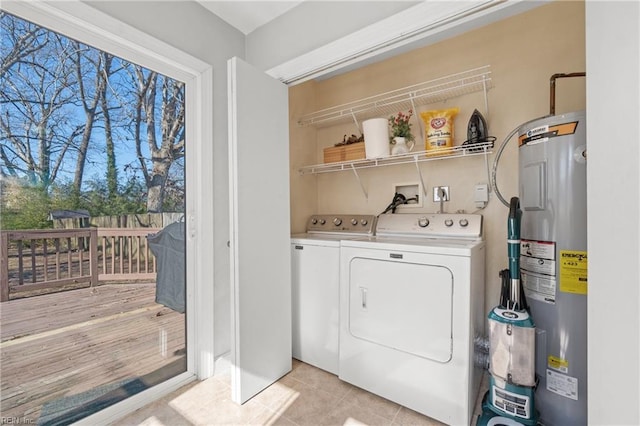 laundry area featuring washer and dryer, electric water heater, and light tile patterned floors