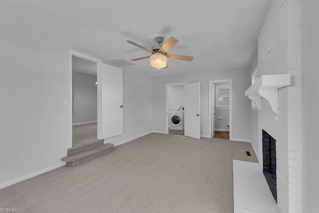 unfurnished living room with light carpet, washer / clothes dryer, a brick fireplace, and ceiling fan