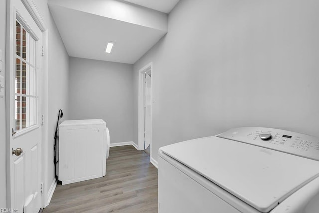 laundry area with washer / clothes dryer and light hardwood / wood-style flooring