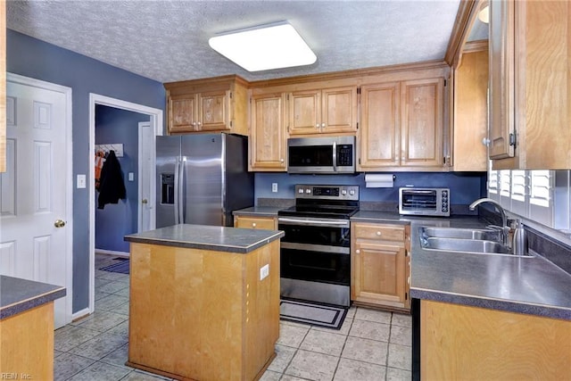 kitchen with sink, a kitchen island, stainless steel appliances, a textured ceiling, and light tile patterned flooring