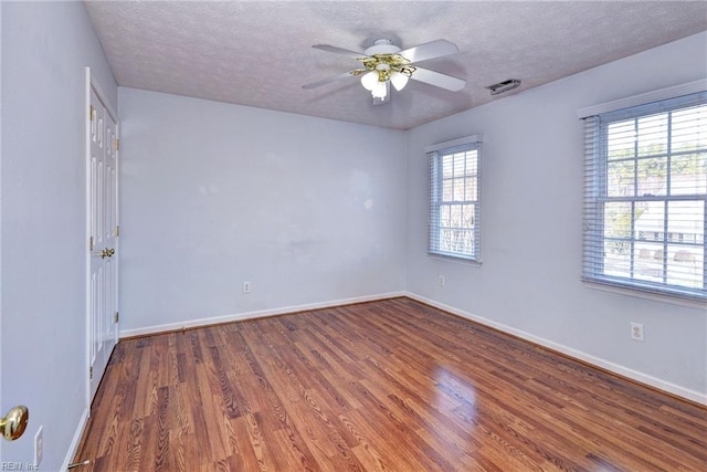 empty room with wood-type flooring, ceiling fan, and a textured ceiling