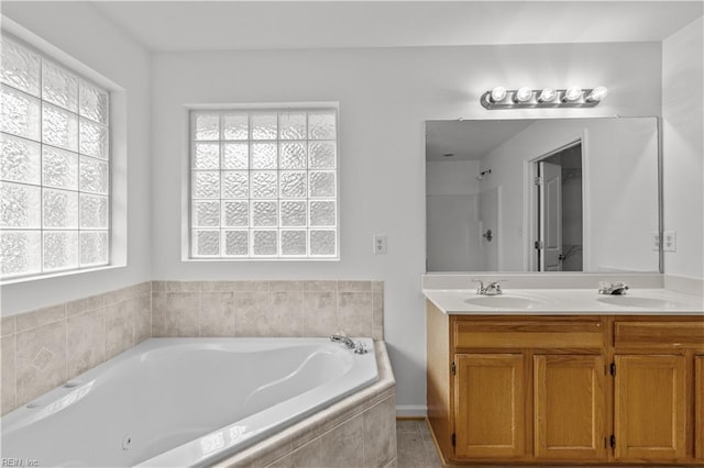 bathroom with vanity and a relaxing tiled tub