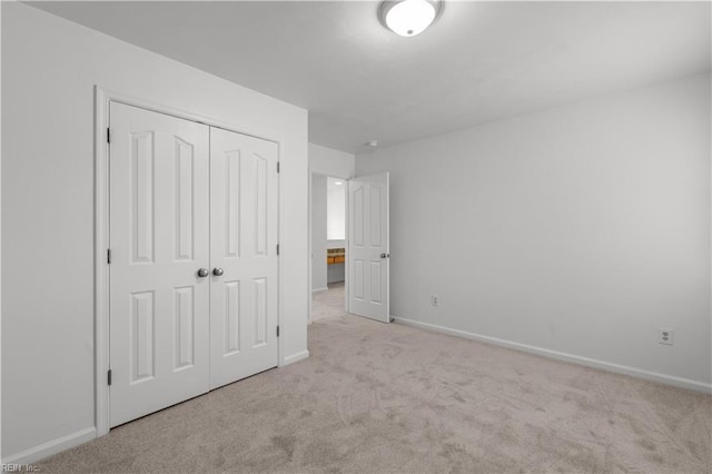 unfurnished bedroom featuring a closet and light carpet